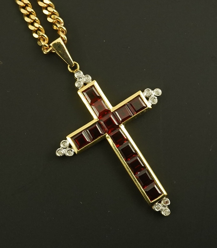 A modern 18ct gold, garnet and diamond chip cluster set cross pendant, 42mm, gross weight 6.5 grams, on a modern 9ct gold curb link chain